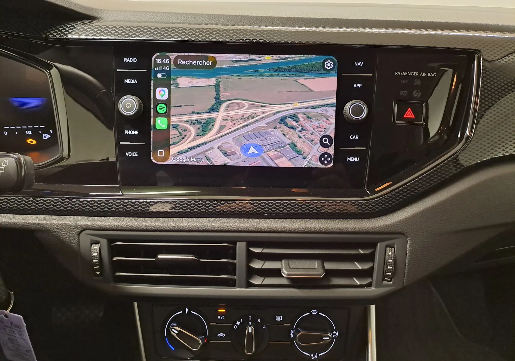 Vue rapprochée de la console centrale de la Volkswagen Polo 2025 gris cendre, avec écran tactile affichant une carte GPS.