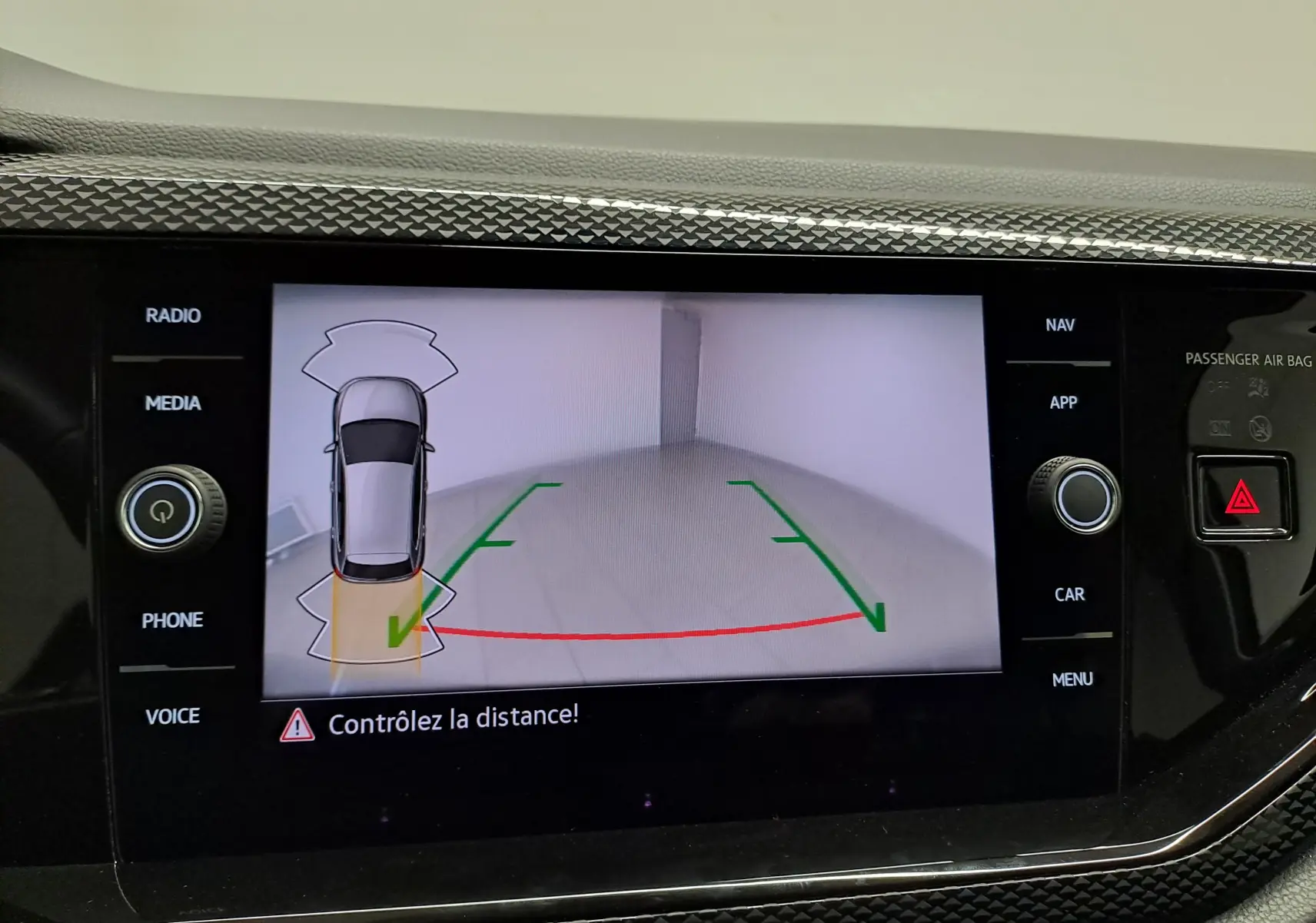 Écran intérieur affichant la caméra de recul et l’aide au stationnement du Volkswagen Polo gris cendre, vue de dessus du véhicule.