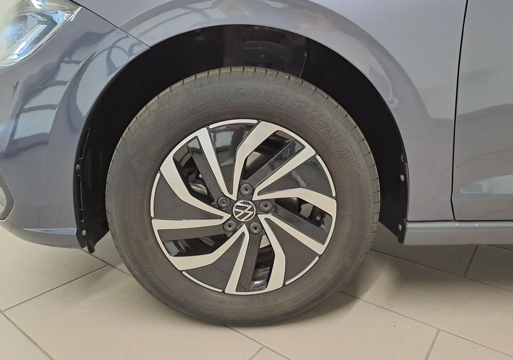 Gros plan sur la roue avant gauche d'une Volkswagen Polo gris cendre 2025 avec jante alliage au design moderne.