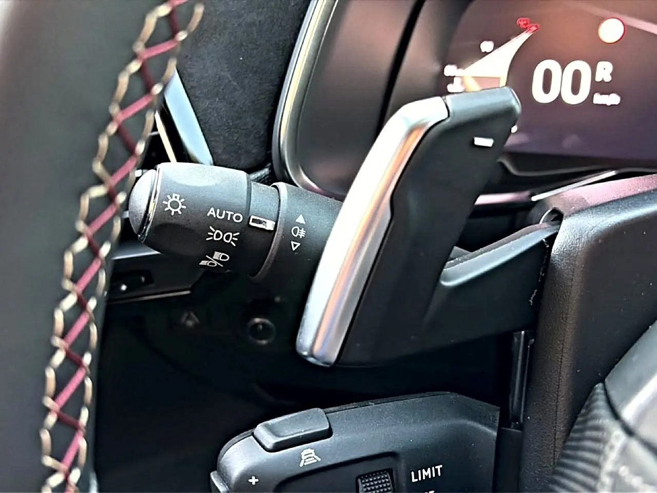 Détail intérieur côté gauche du volant cuir noir avec palettes de changement de vitesse et commandes d’éclairage DS7 noir.