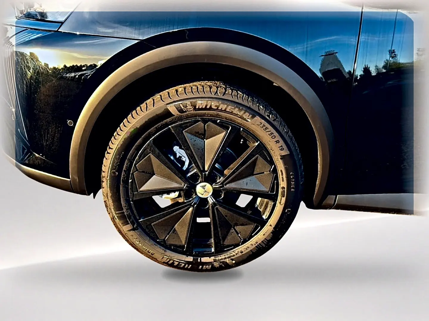 Gros plan sur la roue avant droite noire d'un DS7 1.5 BlueHDi 130 avec jante alu au design géométrique.