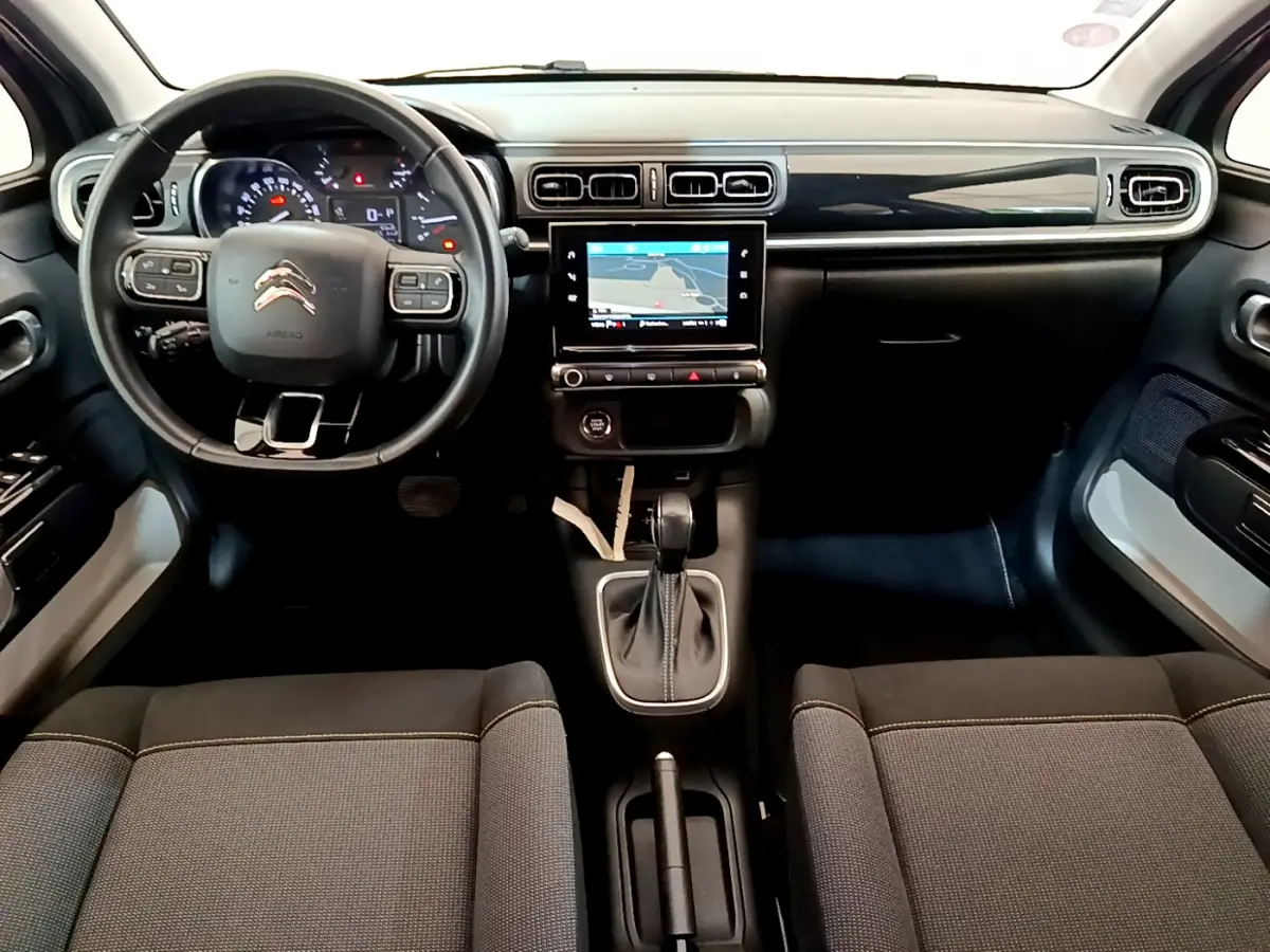 Vue intérieure avant du Citroën C3 gris clair 2019 avec tableau de bord noir et écran tactile central.