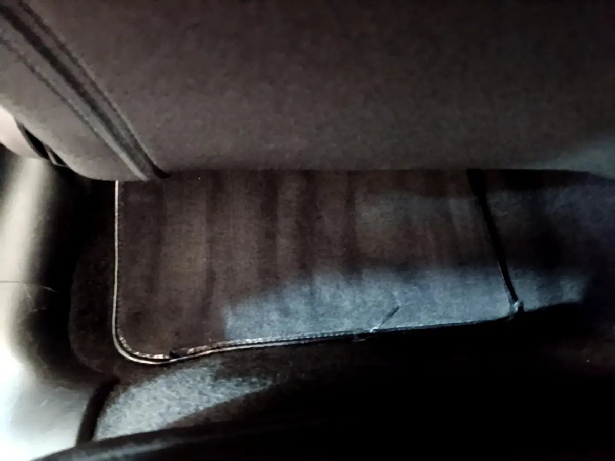 Tapis de sol noir sous le siège avant droit d'une Citroën C3 gris clair, vue rapprochée intérieure