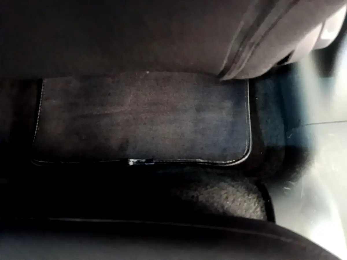 Tapis de sol noir sous le siège arrière côté gauche d'une Citroën C3 gris clair 2019 vue en intérieur.