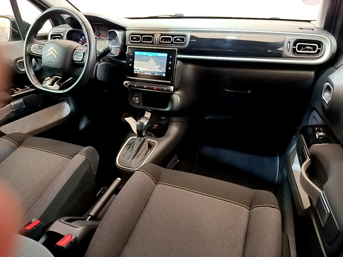 Intérieur avant du Citroën C3 gris clair 2019, avec tableau de bord noir, écran tactile central et volant cuir multifonctions.