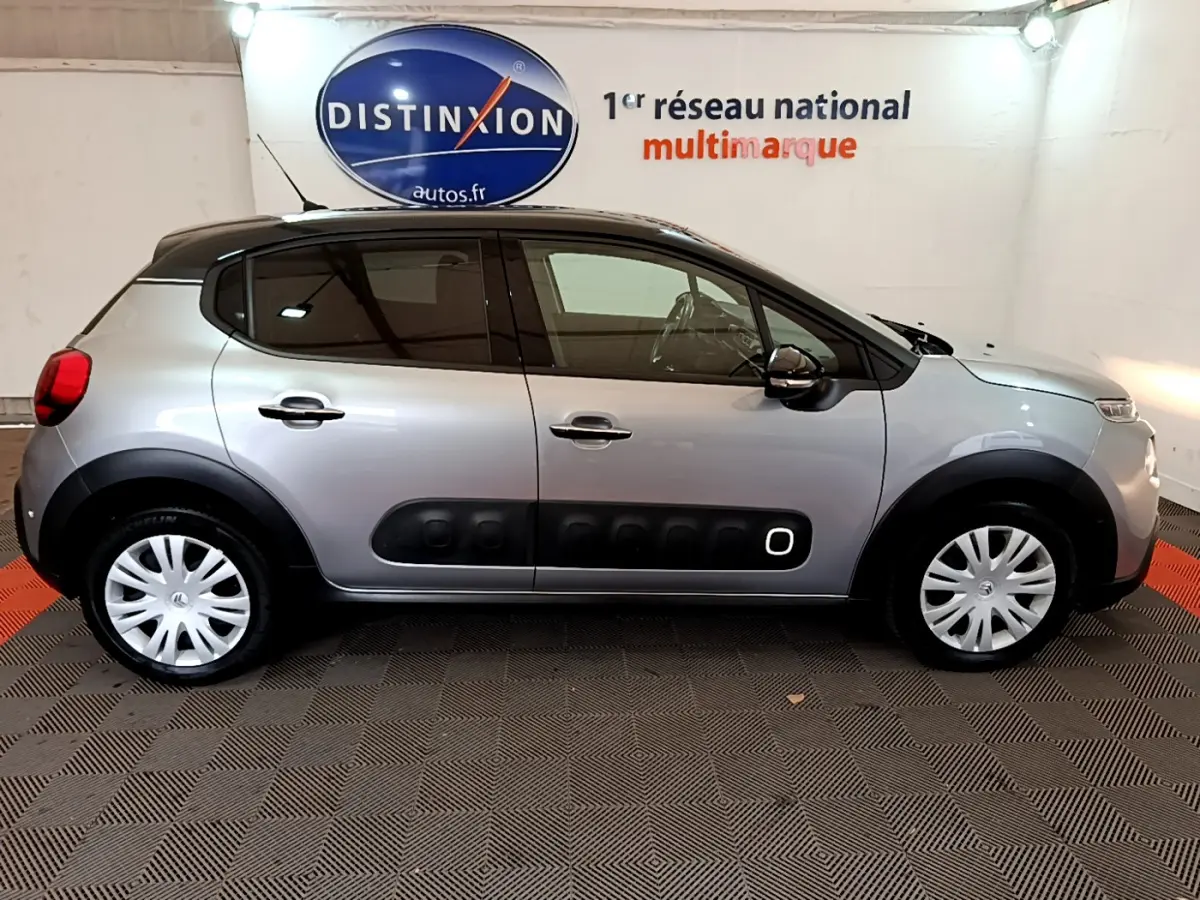 Profil côté gauche d'une Citroën C3 gris clair 2019 avec protections noires caractéristiques et jantes acier.
