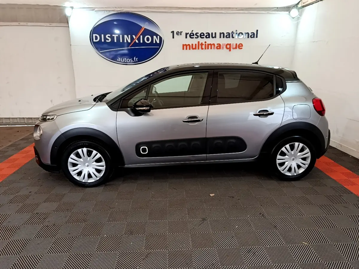 Profil côté gauche d'une Citroën C3 gris clair 2019 avec protections latérales noires et jantes acier blanches.