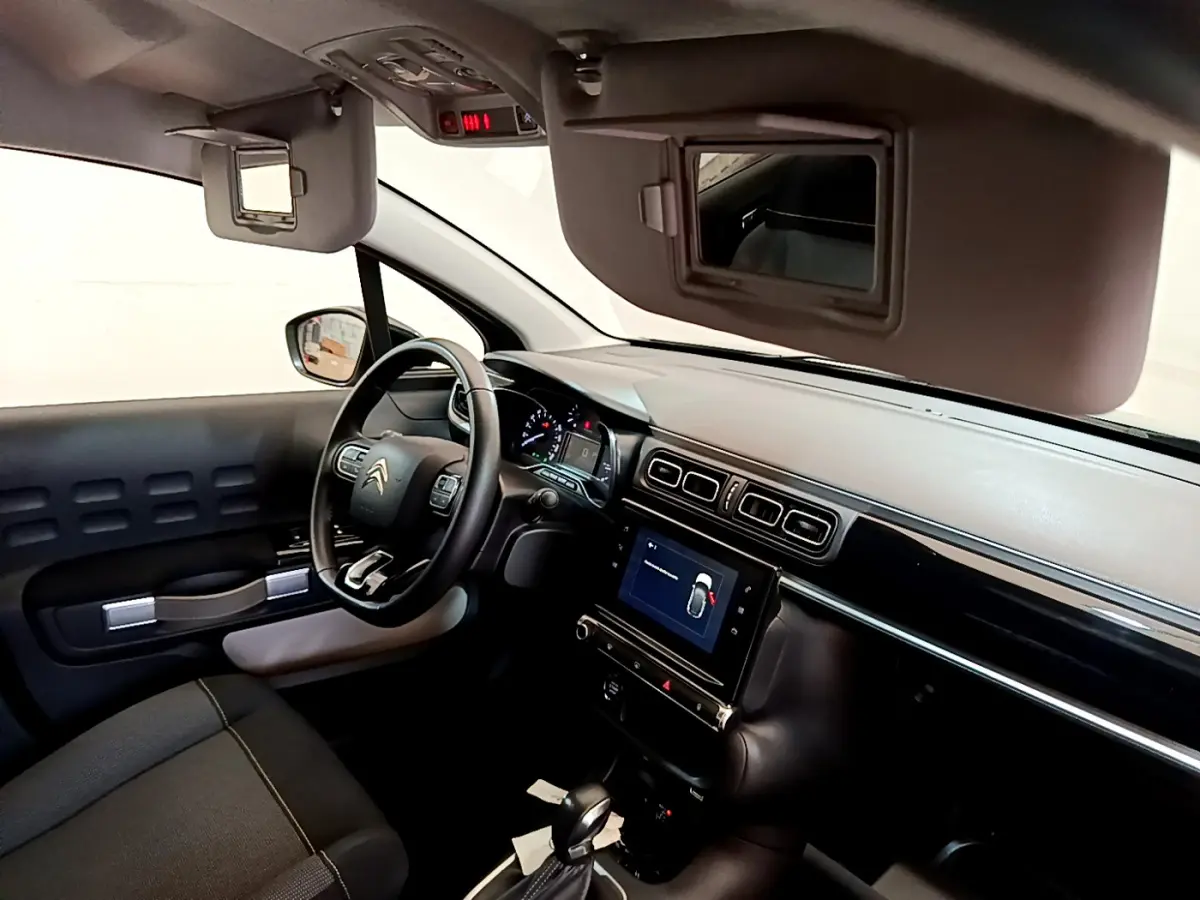 Intérieur de la Citroën C3 2019, vue côté conducteur, tableau de bord noir avec écran tactile central et volant cuir multi-fonctions.