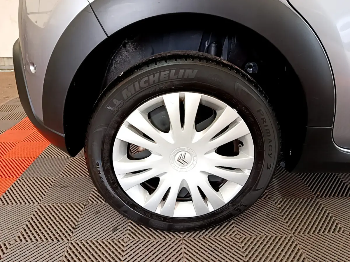 Gros plan sur la roue arrière droite gris clair d'une Citroën C3 2019 avec jante acier et enjoliveur blanc.