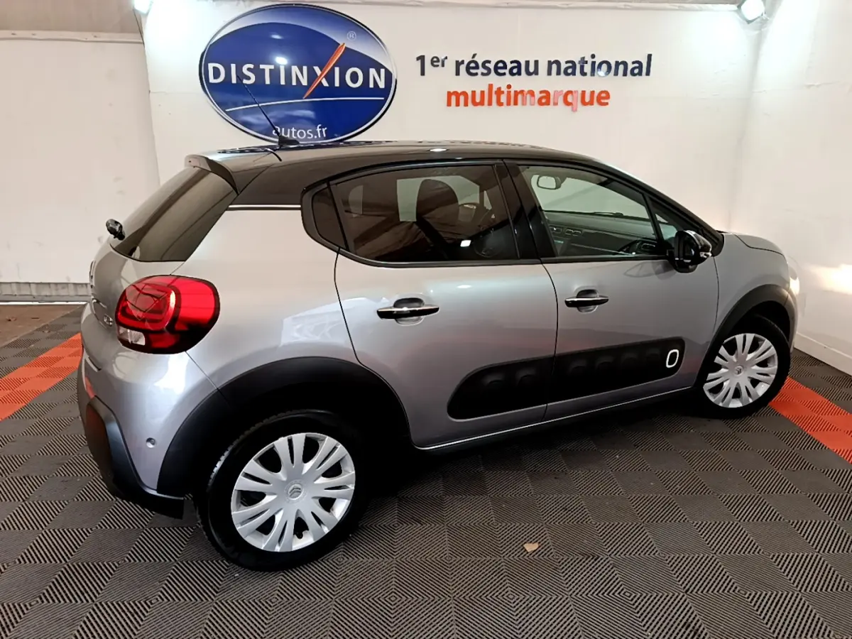 Citroën C3 gris clair vue de profil côté droit, avec protections noires caractéristiques sur les portières.