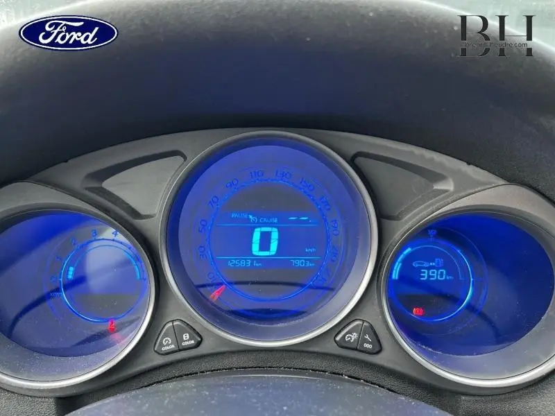 Tableau de bord numérique bleu de Citroën C4 blanc, affichant vitesse, compteurs et autonomie.