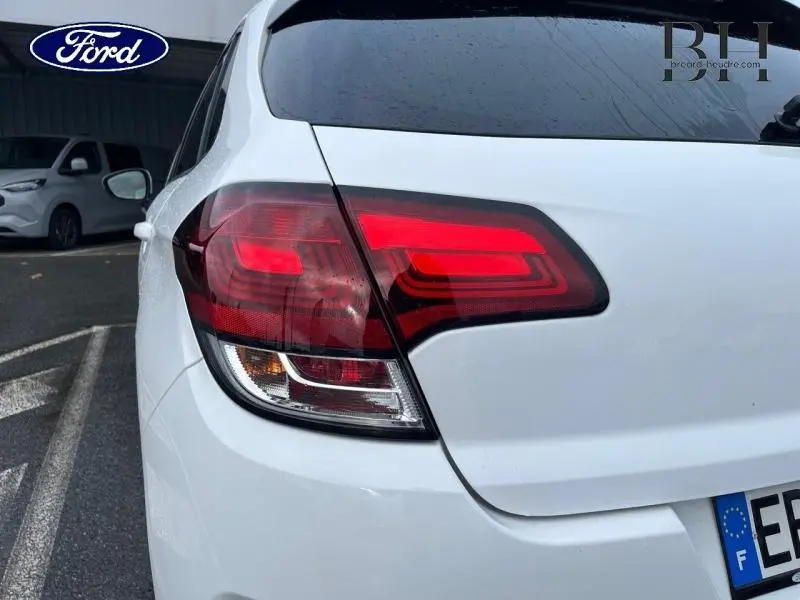 Feu arrière droit d'une Citroën C4 blanche de 2017, avec lunette arrière surteintée visible en extérieur.