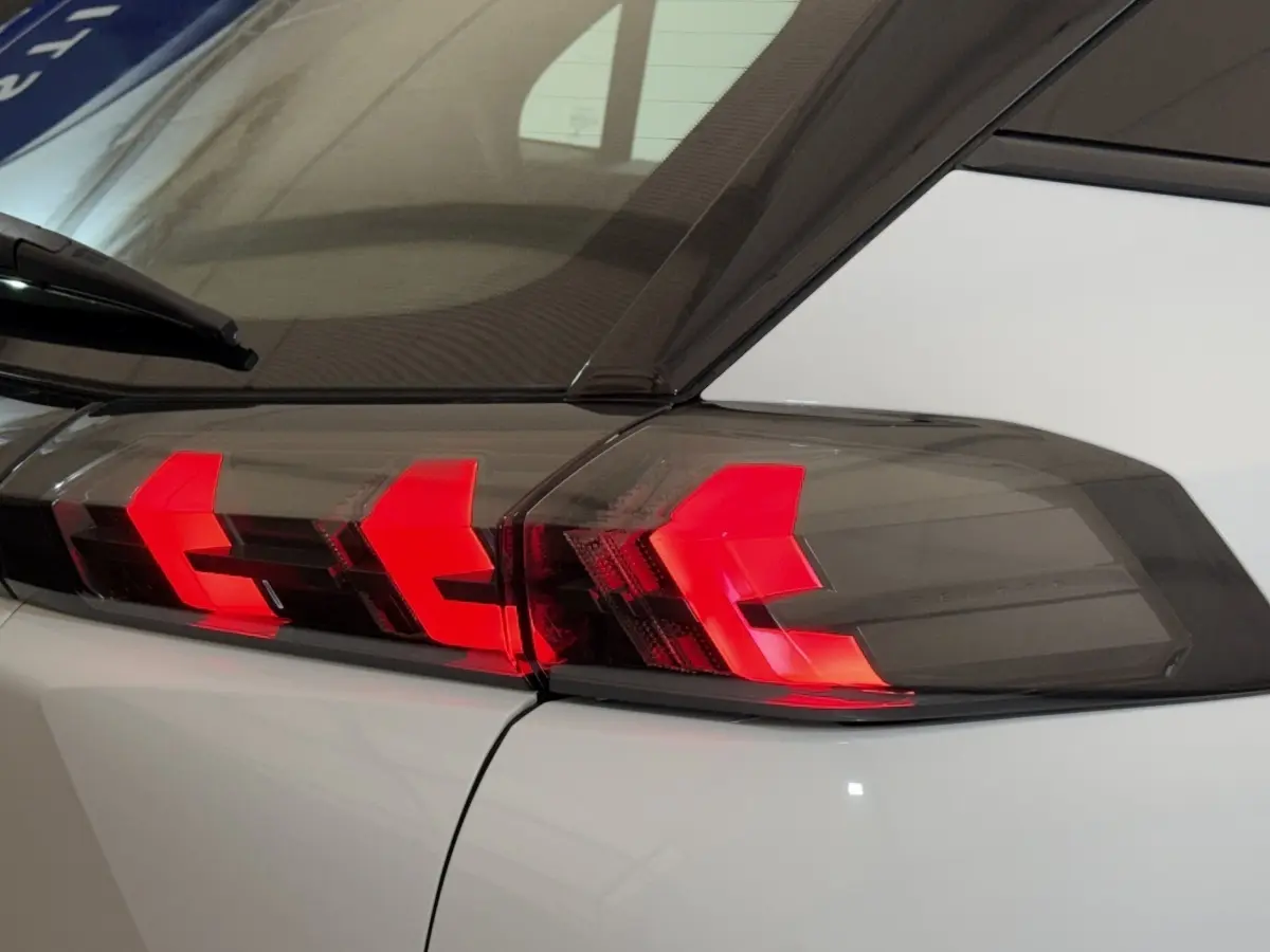 Gros plan sur le feu arrière droit rouge et noir du Peugeot 2008 blanc, vue arrière latérale.