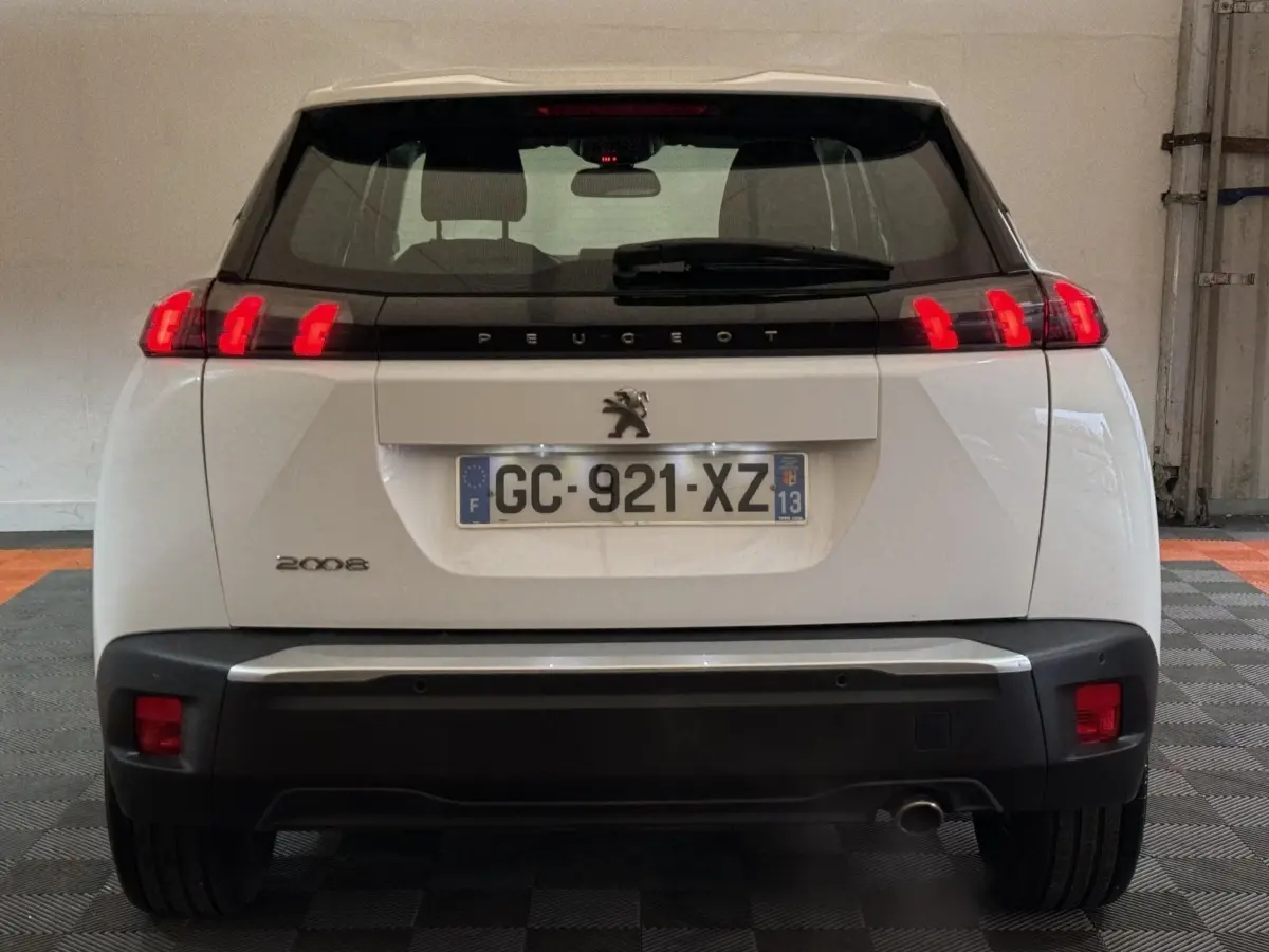 Vue arrière d'un Peugeot 2008 blanc avec feux LED distinctifs et plaque d'immatriculation française visible.
