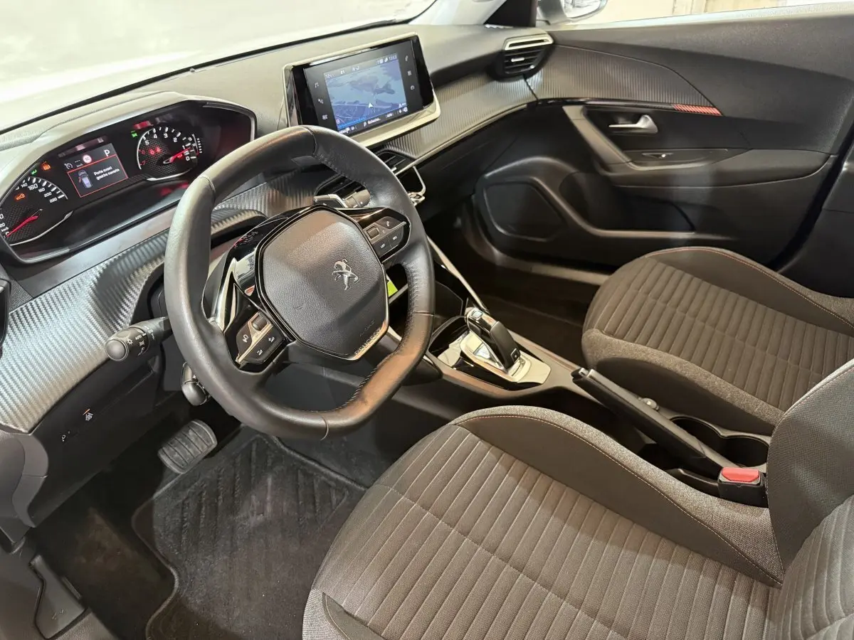 Vue intérieure côté conducteur du Peugeot 2008 2021 avec volant cuir, tableau de bord numérique et écran tactile central.