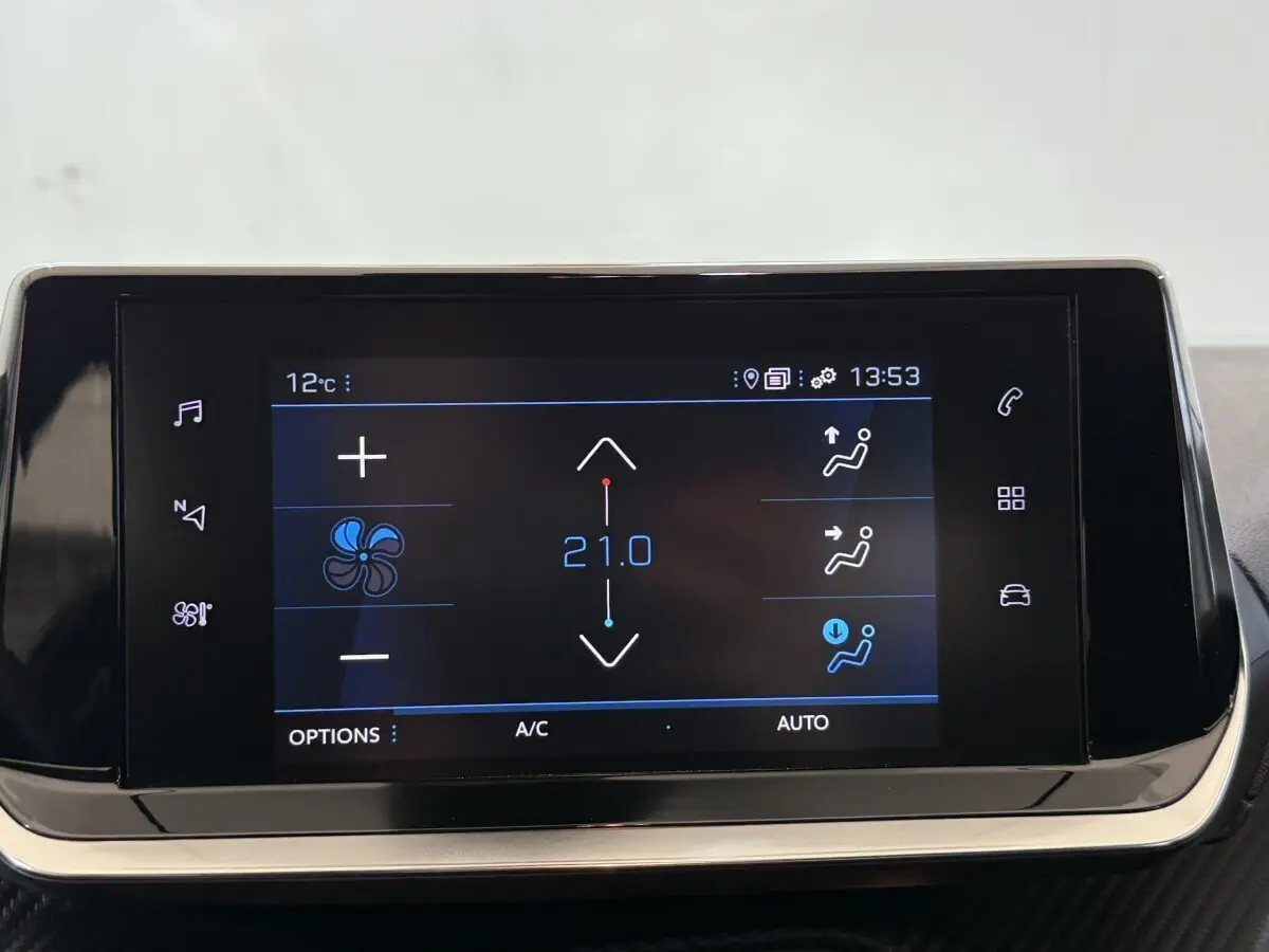 Écran tactile central du tableau de bord du Peugeot 2008 blanc, affichant les réglages de climatisation à 21°C.