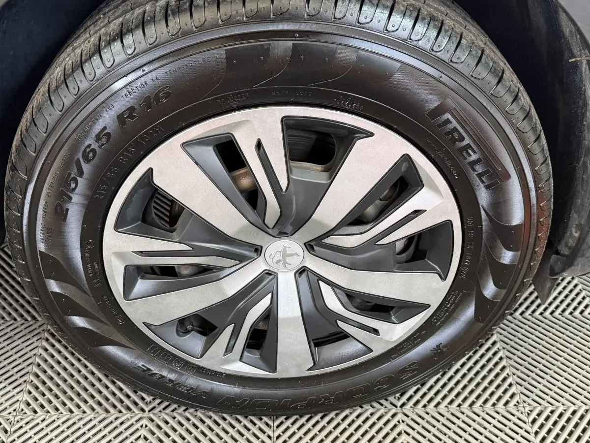 Gros plan sur la roue avant gauche du Peugeot 2008 blanc, avec jante alliage et pneu Pirelli 215/65 R16.