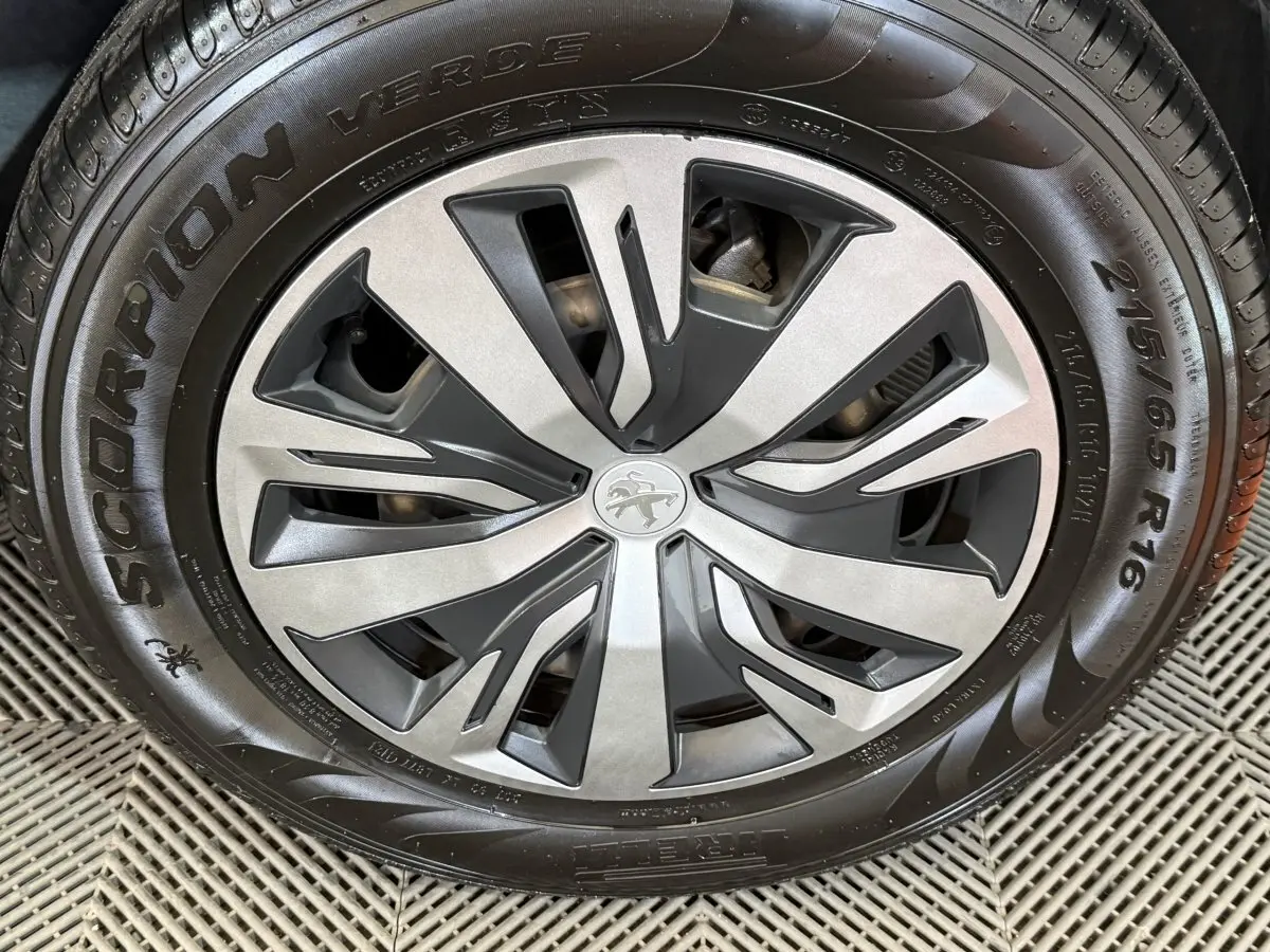 Gros plan sur la jante alliage bicolore et pneu Pirelli Scorpion Verde du Peugeot 2008 blanc de 2021.