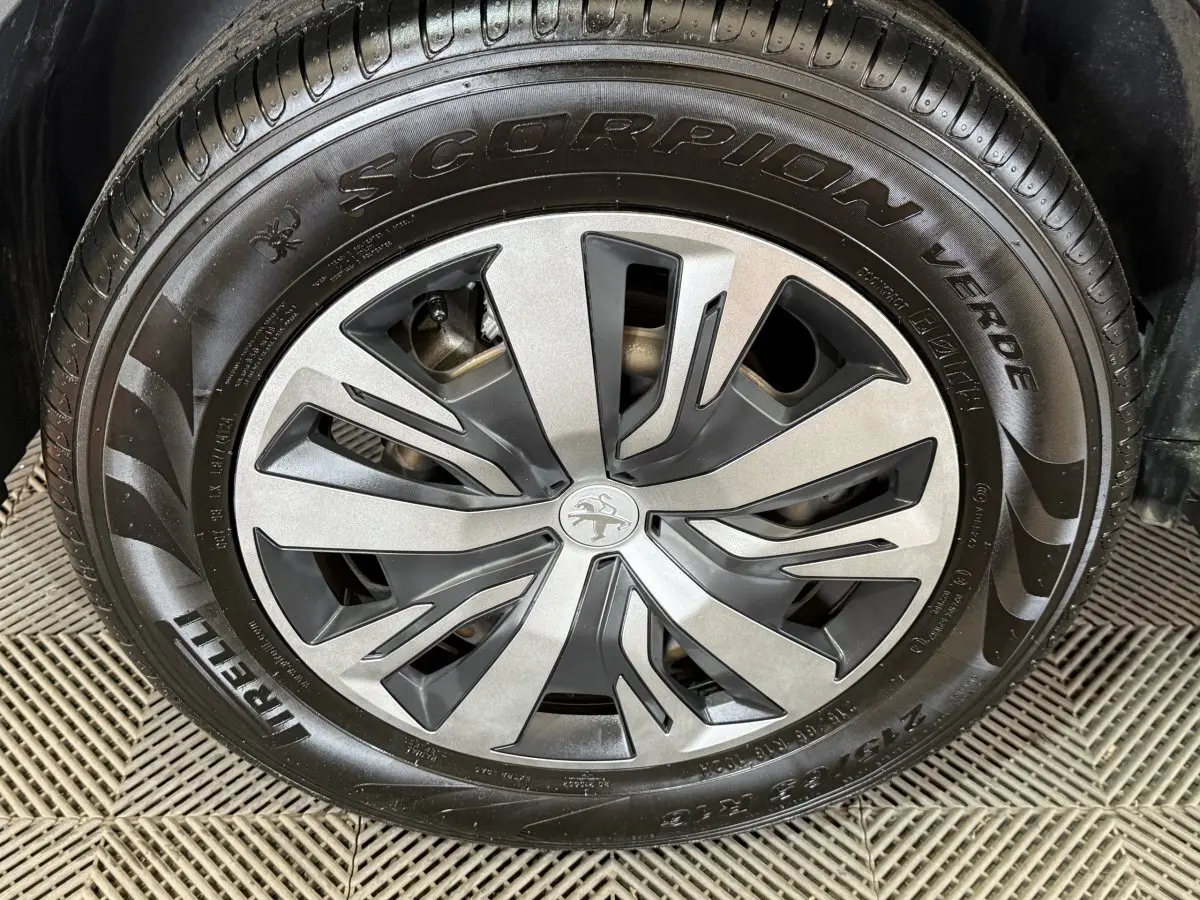 Gros plan sur la jante alliage grise et noire du Peugeot 2008 blanc, avec pneu Pirelli Scorpion Verde visible.