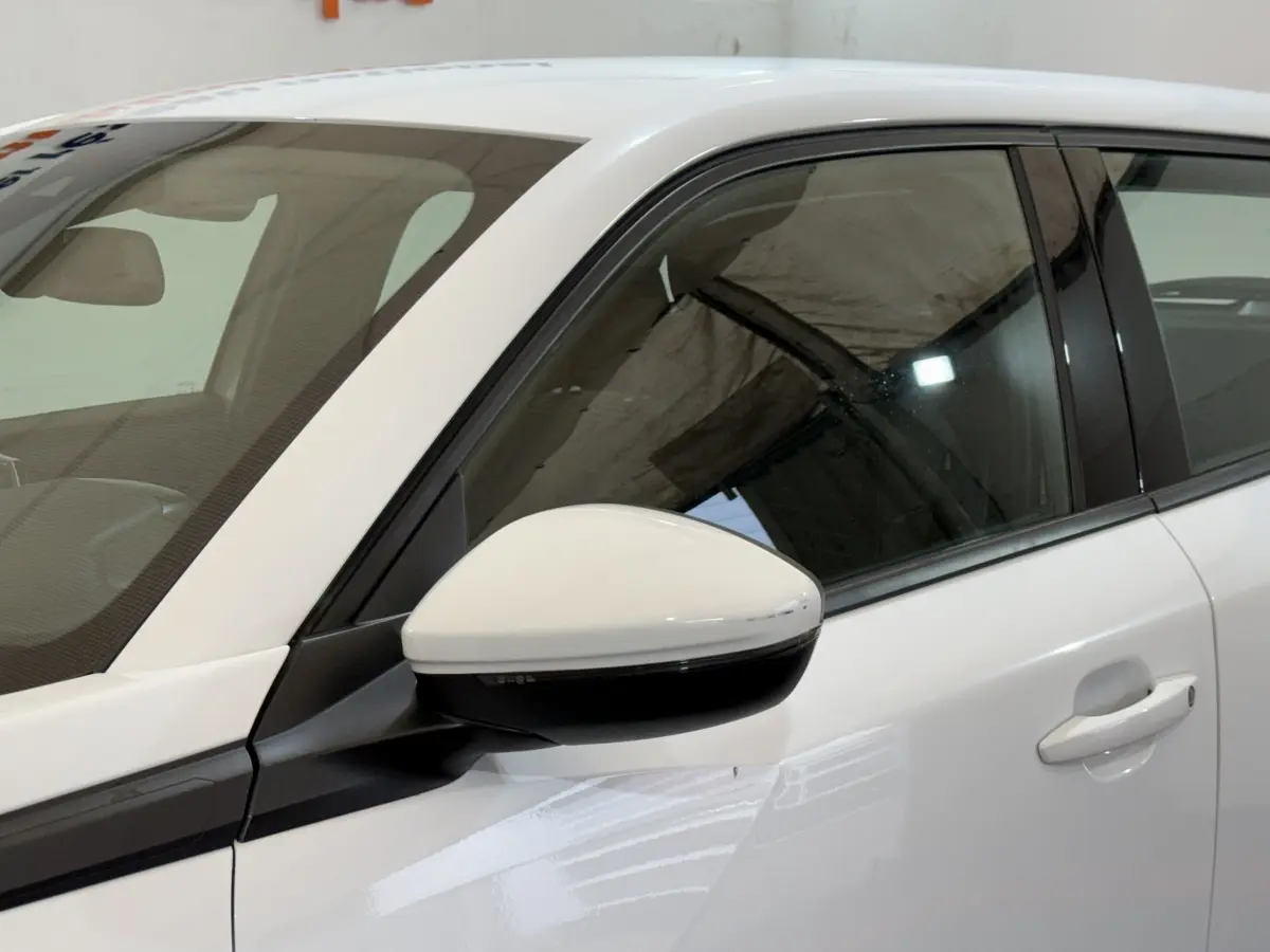 Détail du rétroviseur côté gauche blanc du Peugeot 2008 2021 avec porte et vitre teintée visibles.