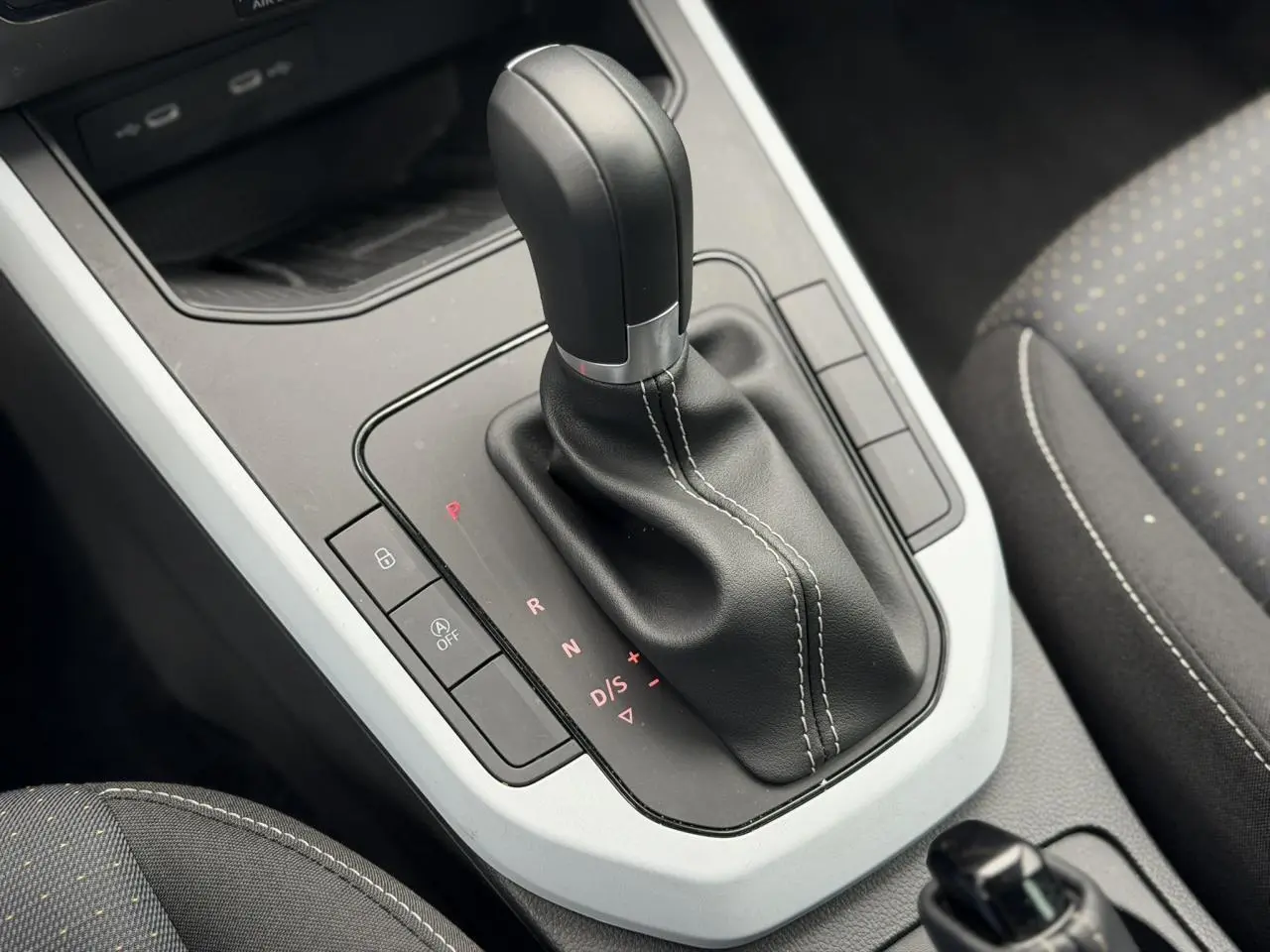 Le levier de vitesse automatique noir avec coutures blanches du SEAT Arona TSI 115 DSG Style, vue intérieure rapprochée.