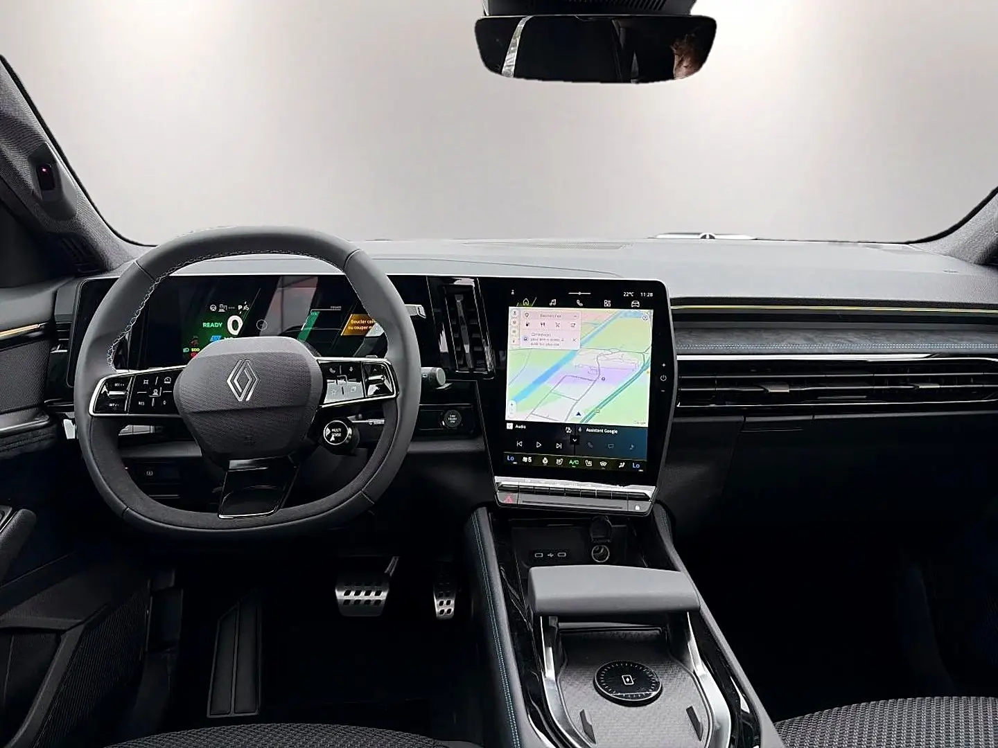 Vue intérieure avant du Renault Austral gris schiste, avec volant multifonction et grand écran tactile central affichant la navigation.