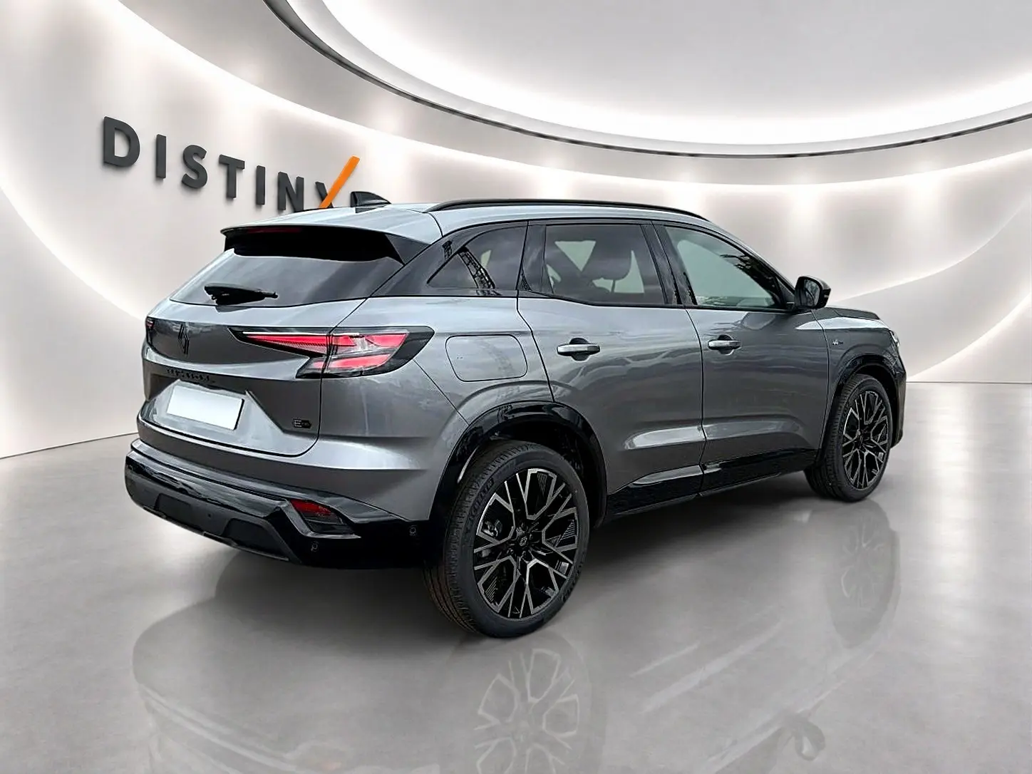 Renault Austral gris schiste en 3/4 arrière droit, avec jantes alu noires et toit noir contrasté dans un studio lumineux.