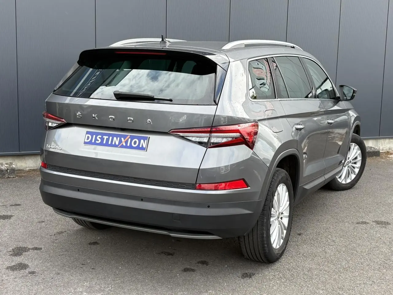 Vue 3/4 arrière droite d'un Skoda Kodiaq gris graphite avec feux arrière LED et jantes alliage 18 pouces.