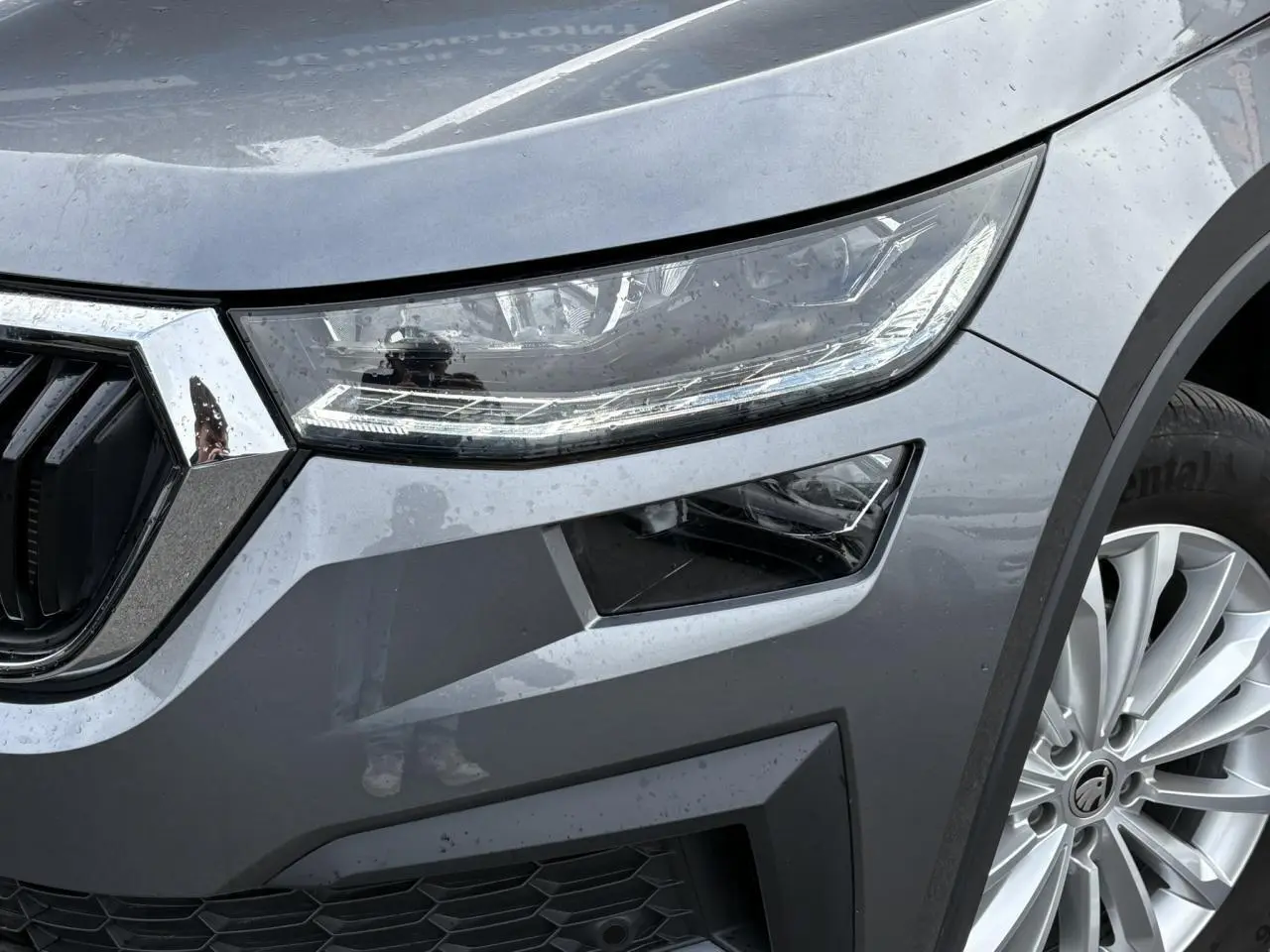 Gros plan sur l'avant droit du Skoda Kodiaq gris graphite, mettant en valeur le phare LED et la jante alliage 18 pouces.