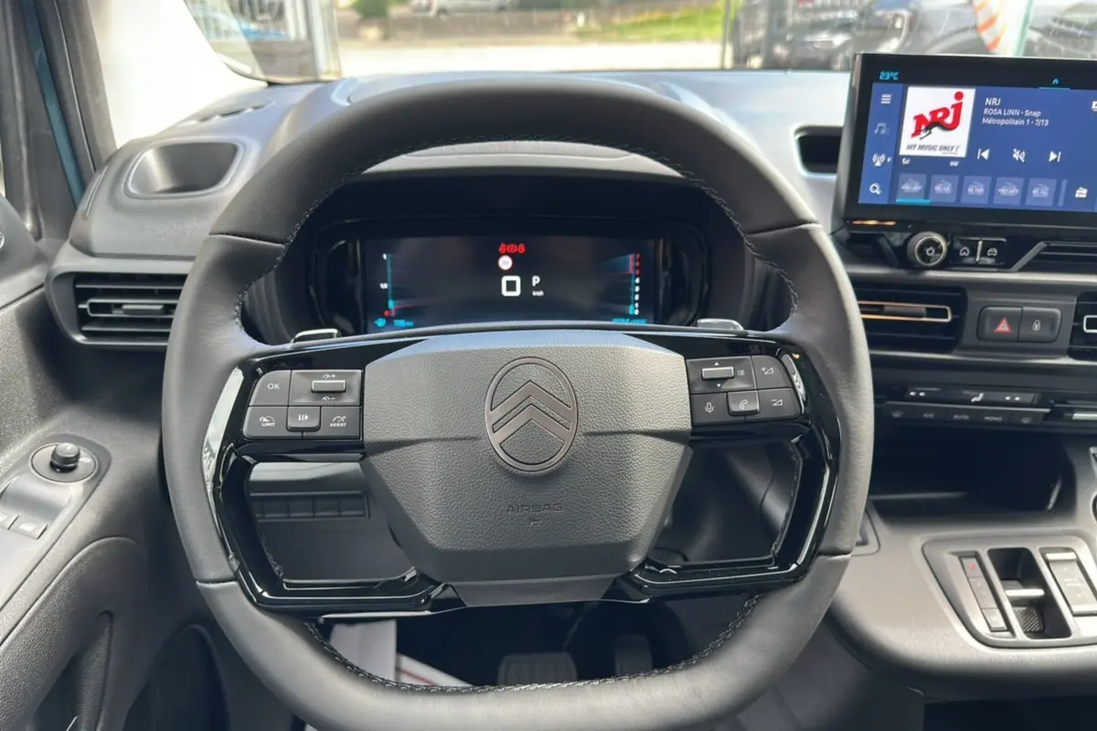 Vue intérieure centrée sur le volant du Citroën Berlingo 2025 Kiama blue, avec tableau de bord digital et écran tactile.