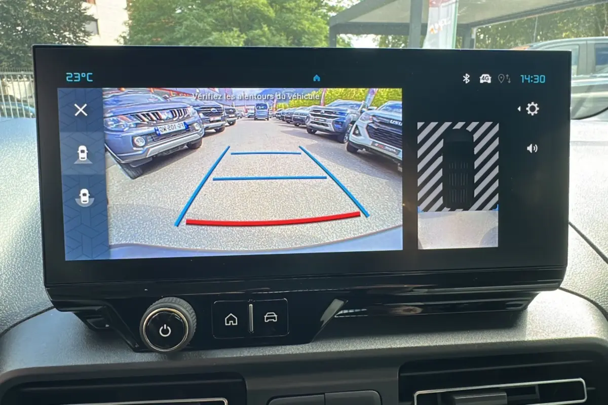 Vue intérieure du tableau de bord du Citroën Berlingo 2025 avec écran affichant la caméra de recul et les aides au stationnement.