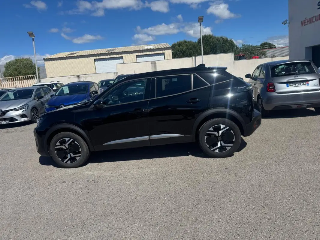 Peugeot 2008 Hybrid 136 e-DCS6 Allure noir vue de profil côté gauche, avec jantes distinctives et pack hiver visible.