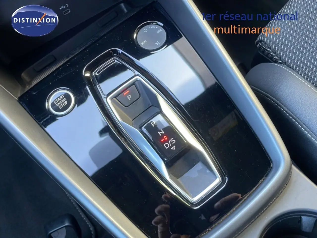 Gros plan sur la console centrale noire brillante de l'Audi A3 Sportback 40 TFSIe, avec levier de vitesses automatique et bouton start/stop.