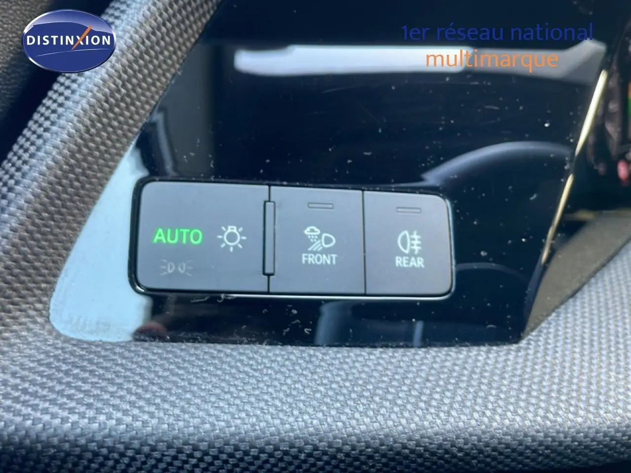 Détail du tableau de bord de l'Audi A3 Sportback 2025 avec boutons de réglage des phares sur fond noir brillant.