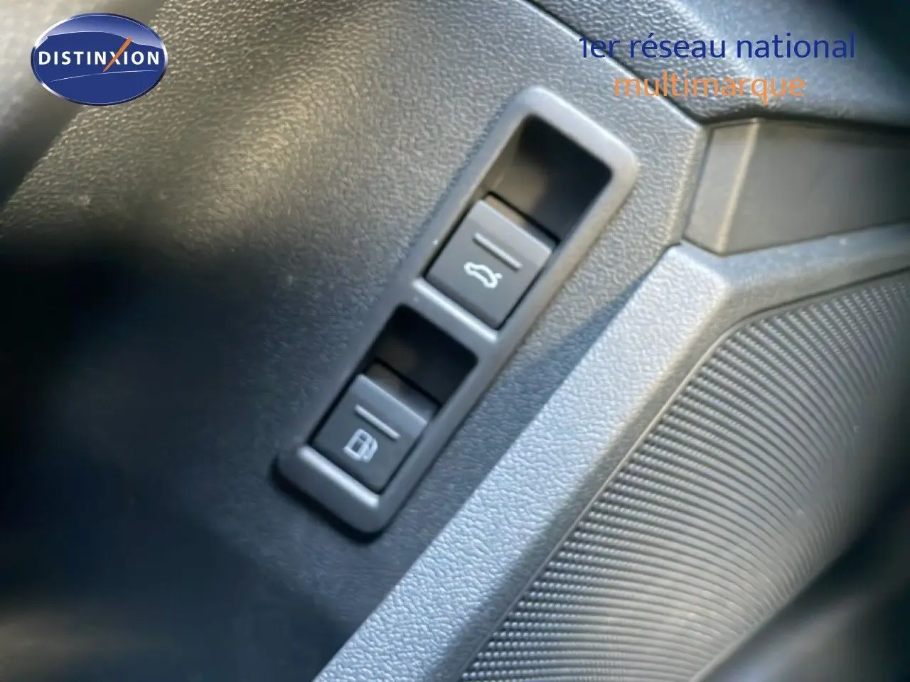 Gros plan sur les boutons d’ouverture du coffre et de la trappe à carburant dans l’habitacle d’une Audi A3 Sportback noire.