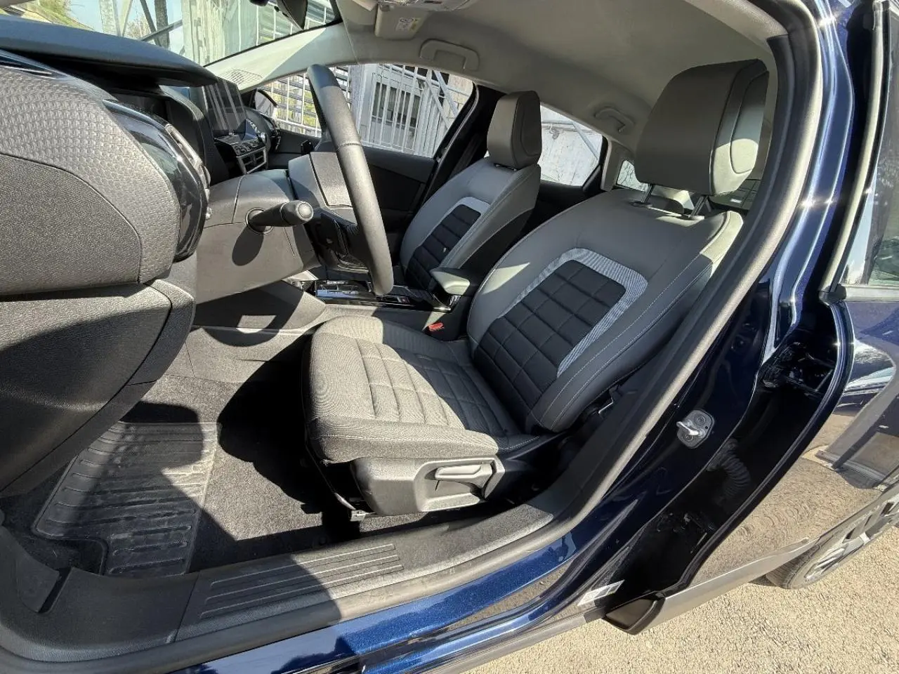 Intérieur côté conducteur du Citroën C4 2025 bleu eclipse, montrant les sièges tissu et tableau de bord moderne.