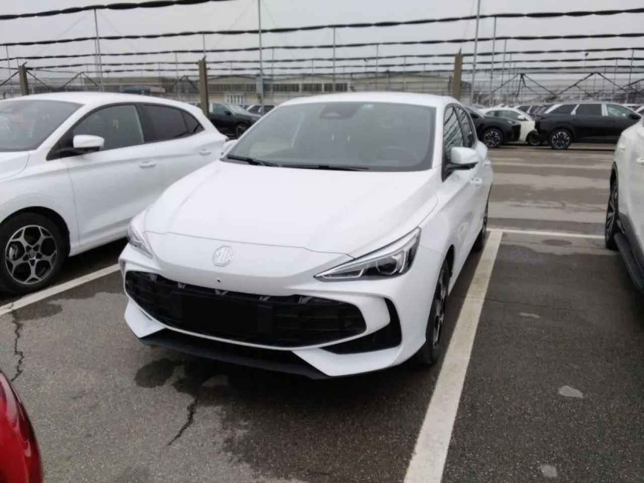 MG3 blanc Dover en 3/4 avant droit sur parking, avec calandre noire et phares LED distinctifs.