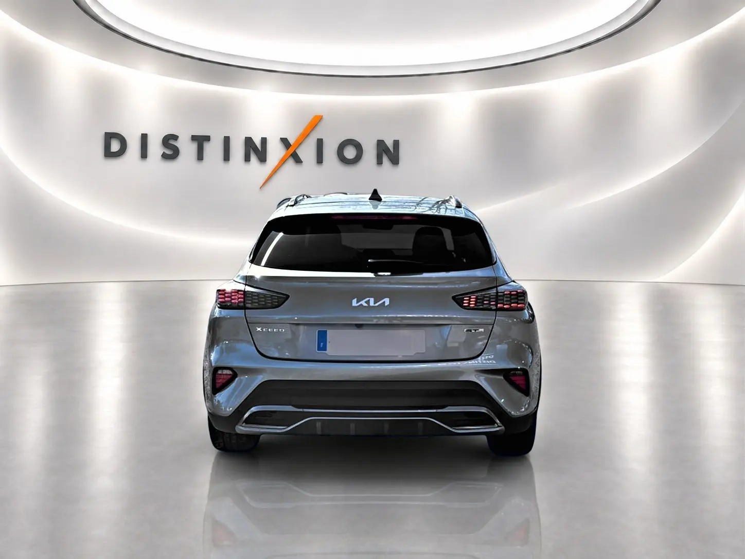 Vue arrière d'une KIA Xceed gris métallisé 2024 avec feux LED et logo distinctif dans un showroom lumineux.