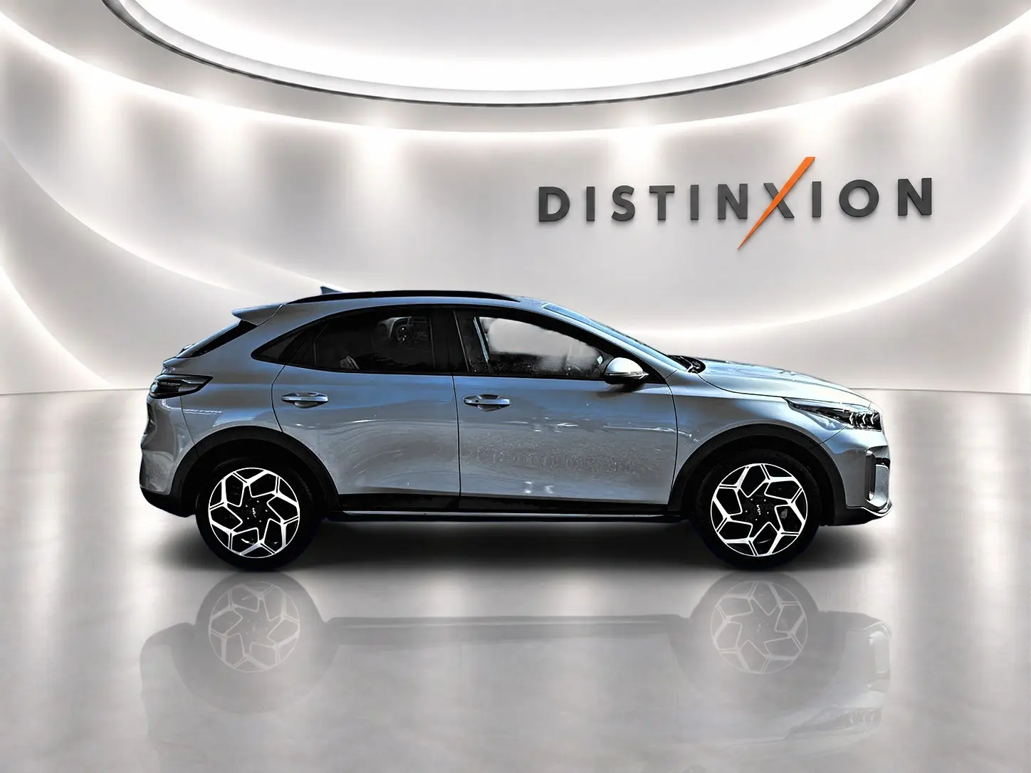 KIA Xceed gris en profil droit dans un showroom avec jantes alu au design moderne et toit noir contrasté.