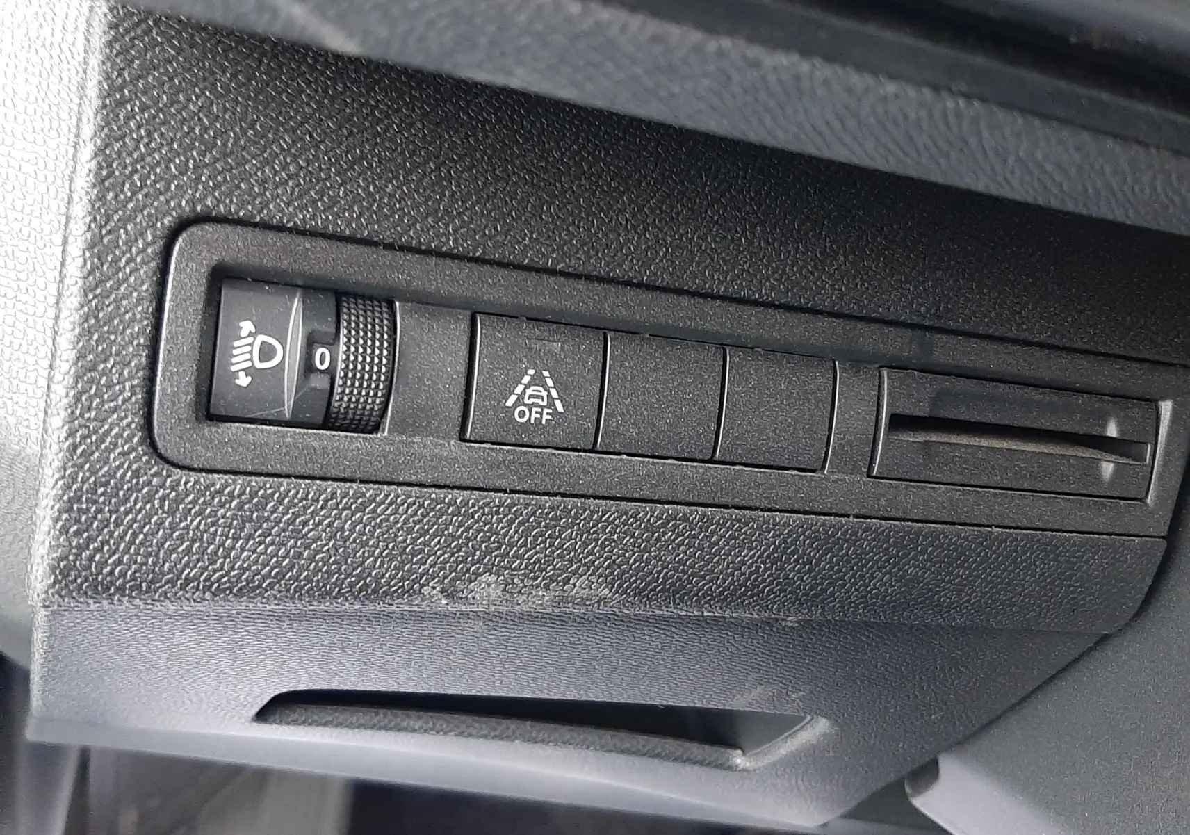 Détail des commandes de réglage d'éclairage et d'aide à la conduite sur le tableau de bord du Peugeot 3008 Hybrid 2024.