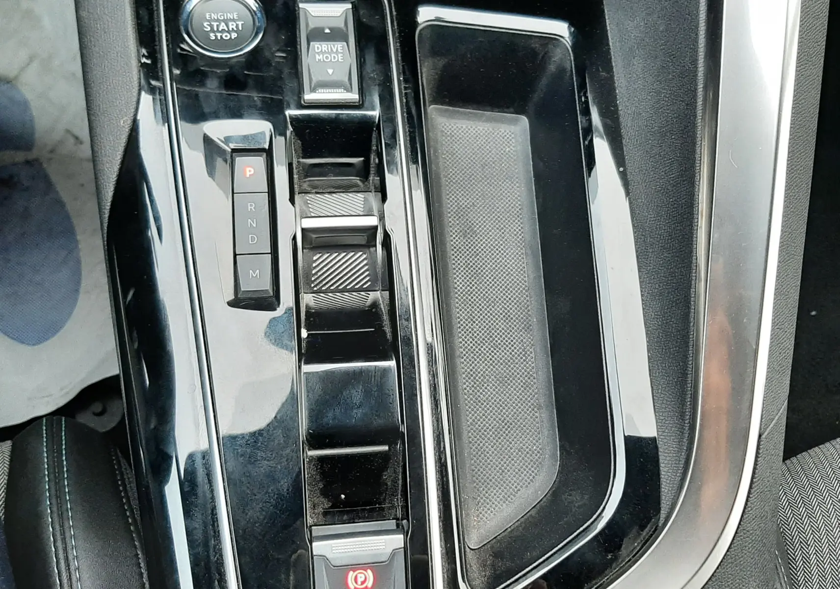 Vue rapprochée de la console centrale noire brillante du Peugeot 3008 Hybrid 136 e-DCS6 Allure Pack avec bouton start et levier de vitesses.