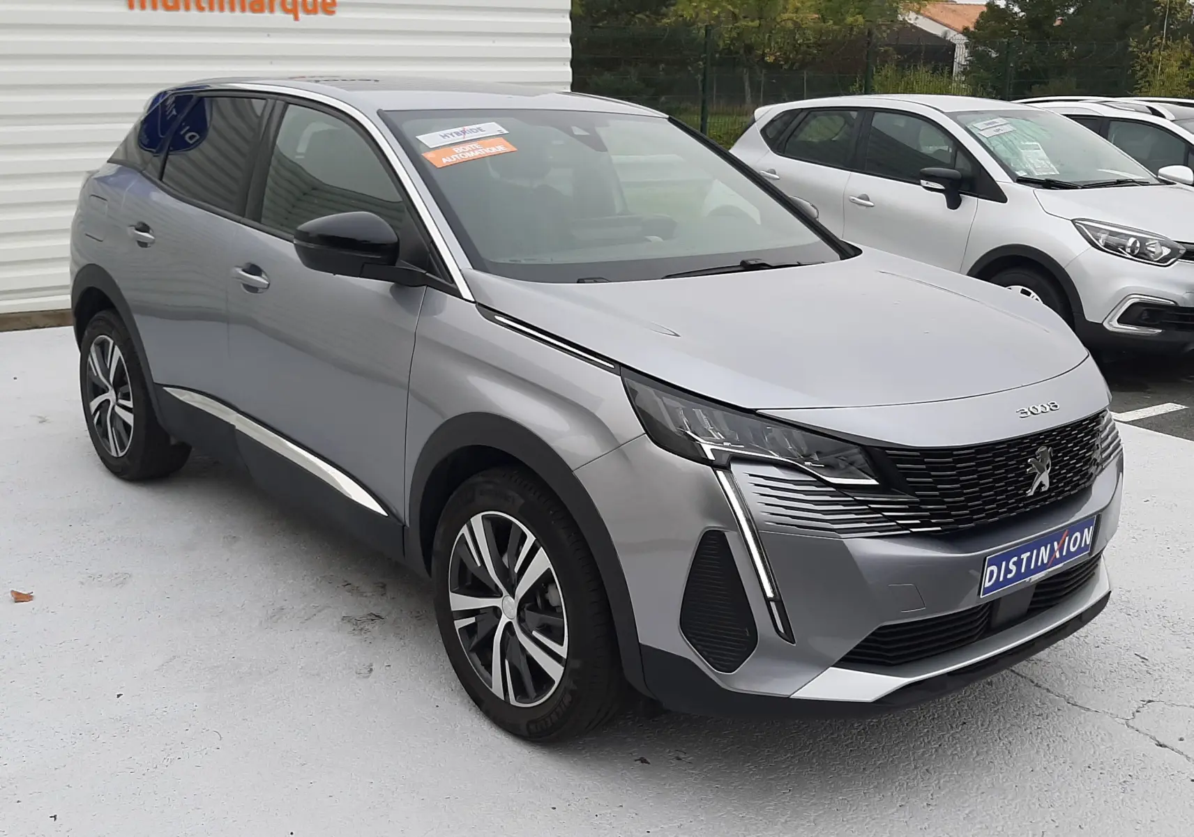 Peugeot 3008 HYBRID gris Artense en vue 3/4 avant droit, avec calandre noire et feux LED verticaux distinctifs.