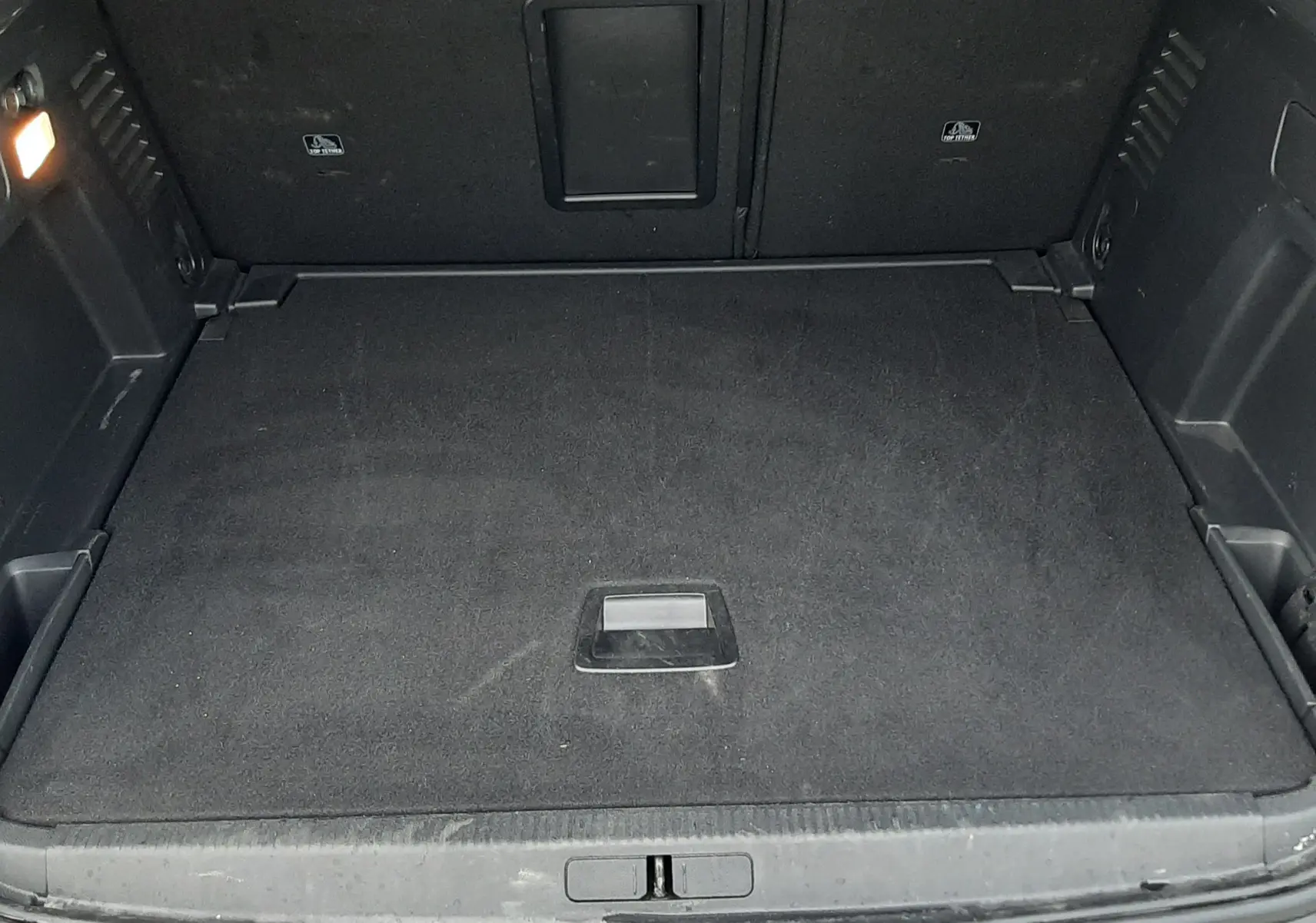 Coffre spacieux ouvert du Peugeot 3008 Hybrid gris Artense, montrant le plancher plat et les parois intérieures noires.