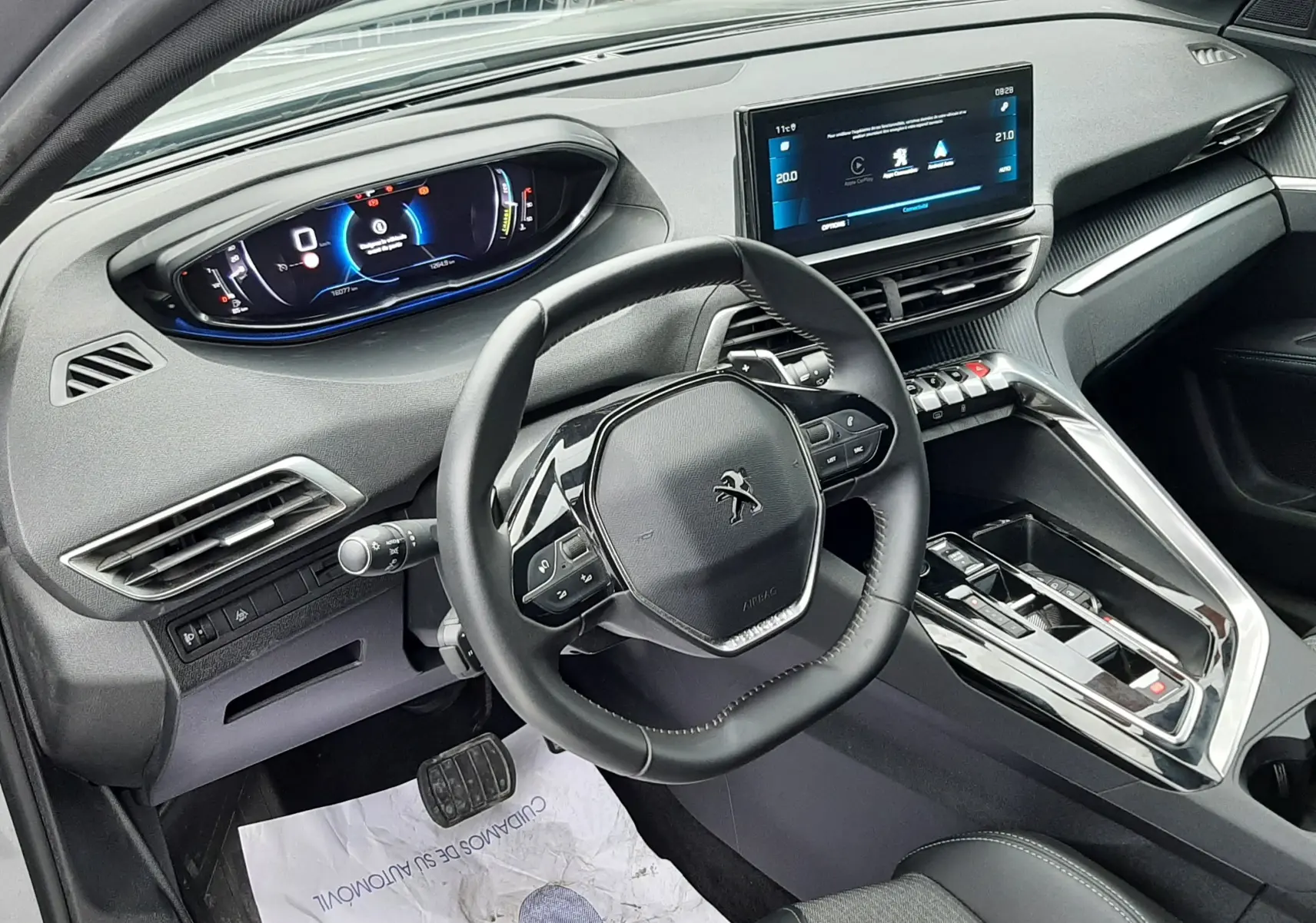 Vue intérieure côté conducteur du Peugeot 3008 Hybrid 136 e-DCS6 Allure Pack 2024 avec tableau de bord numérique et volant compact noir.