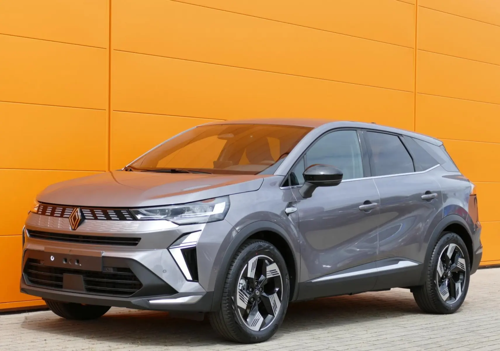 Vue 3/4 avant droite du Renault Symbioz gris Cassiopée avec ses jantes bicolores et calandre moderne.