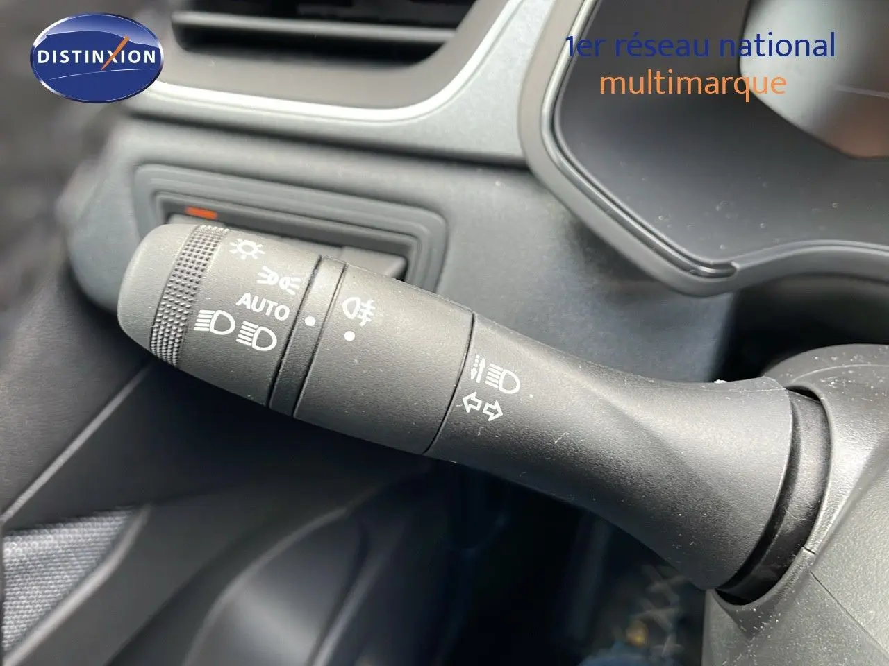 Gros plan sur la commande des feux et clignotants à gauche du volant dans l'habitacle du Renault Captur 2025.