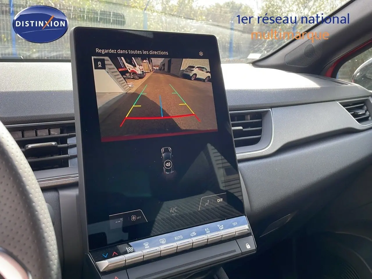 Vue intérieure du tableau de bord du Renault Captur E-Tech rouge, avec écran tactile affichant la caméra de recul.