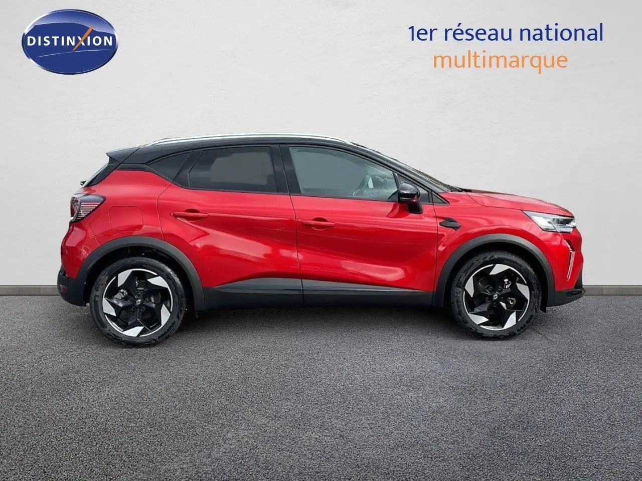 Profil droit du Renault Captur E-Tech hybride 2025 rouge passion avec toit noir et jantes bicolores distinctives.