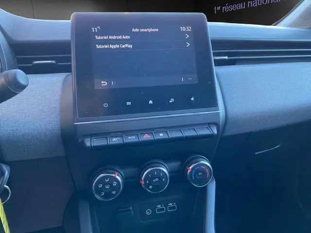 Vue intérieure centrée sur la console centrale de la Renault Clio V gris schiste, avec écran tactile Easy Link et commandes climatisation.