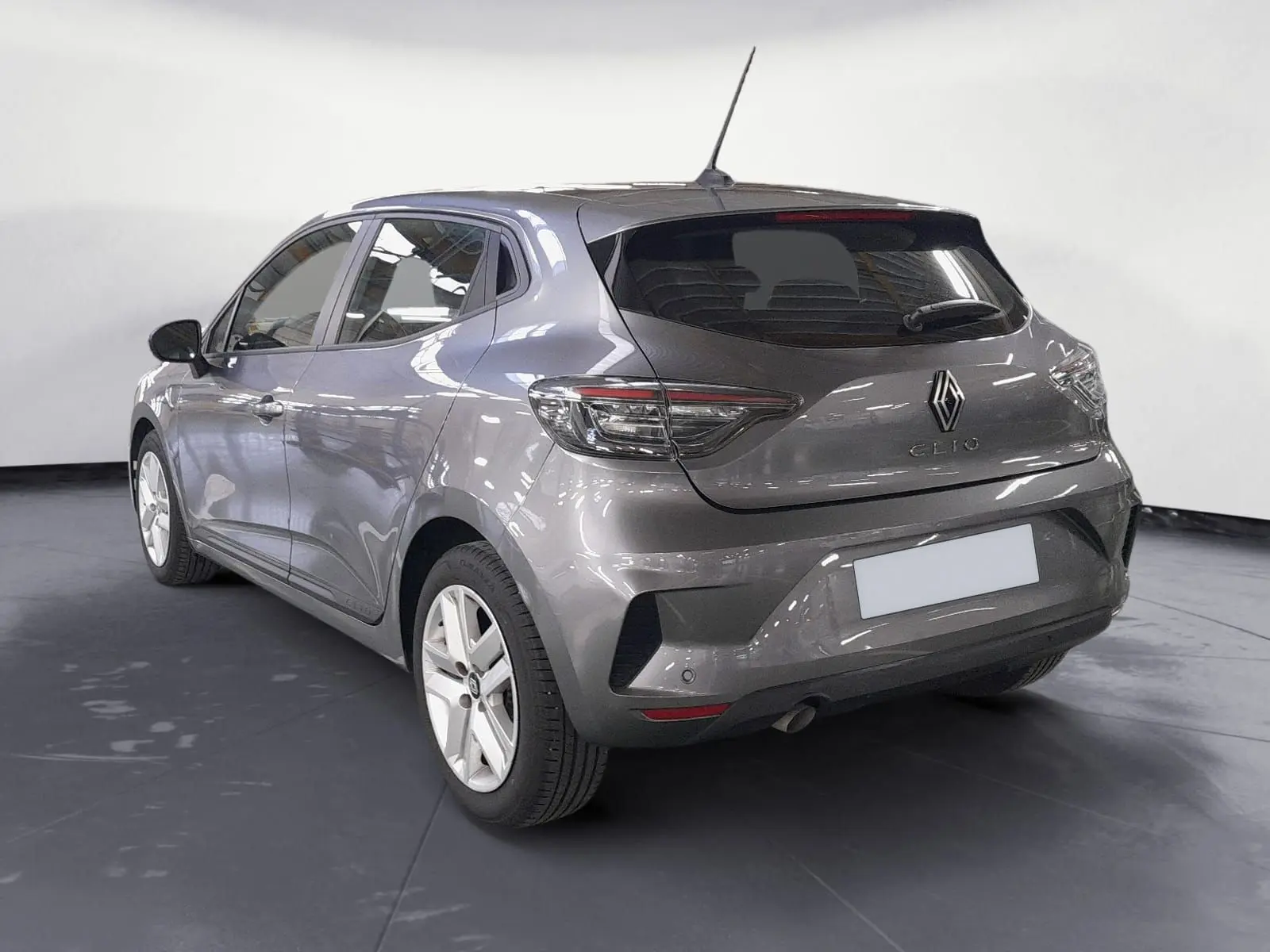 Vue 3/4 arrière droite d'une Renault Clio V gris schiste avec feux LED et jantes tôle 16 pouces en intérieur studio.